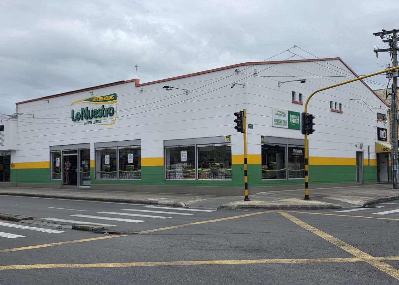 Fachada de una sede de esquina en blanco, verde y amarillo